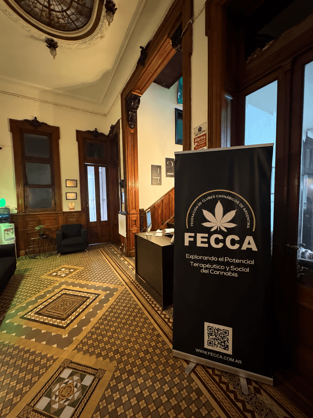 Interior de la sede de FECCA, con su recepción, escalera y cartel institucional